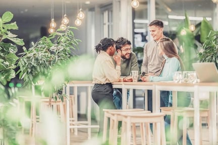 webimage-Diverse startup team collaborating in modern office lounge