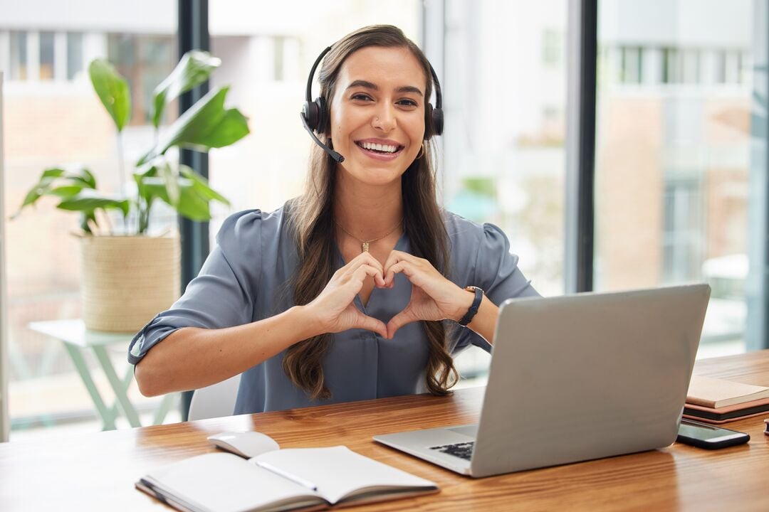 Web_Desktop-Woman, call center and laptop with heart gesture for telemarketing, customer service or support at the office. Portrait of happy employee